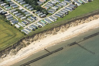 Coastal erosion between a caravan park and the sea defences at Corton Cliffs, Suffolk, 2019. Creator: Historic England.