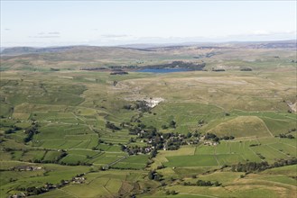View, from the south, over the village of Malham towards Malham Cove and Malham Tarn, North Yorkshire, 2019.
