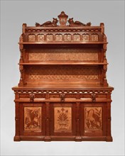 Sideboard, 1868/80. Large walnut sideboard with two shelves, animal designs on doors, gryphons at top.