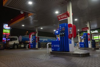 Esso petrol station forecourt with tanker delivering fuel, 2020.
