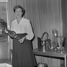 Mary Coldicott holding a brass ornamental gift, during her retirement presentation, 01/08/1986. Creator: John Laing plc.
