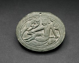 Oval Cosmetic Box Lid with a Man Being Entertained by a Lyrist, 5th/6th century. Ancient region of Gandhara (modern Pakistan).