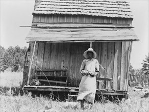 Sharecropper's cabin and sharecropper's wife, Ten miles south of Jackson, Mississippi, 1937. Creator: Dorothea Lange.