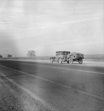 Migrant family on U.S. Highway 99 between Bakersfield and Famoso, California, 1936. Creator: Dorothea Lange.