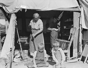 Aged woman with three of her twenty-two grandchildren, Kern county migrant camp, California, 1936. Creator: Dorothea Lange.