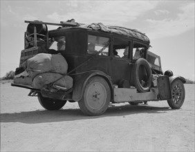 Family...from Fort Smith, Arkansas, trying to repair their car..., Arizona, 1937. Creator: Dorothea Lange.