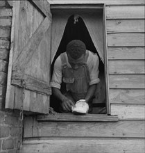 Negro field hand getting ready to go to town on a Saturday afternoon, 1937. Creator: Dorothea Lange.