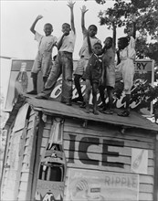 Colored boys playing on top of Coca Cola stand, Little Rock, Arkansas, 1938. Creator: Dorothea Lange.