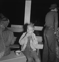 Hungry boy at the Halloween party for migrant workers, Shafter migrant camp, California, 1938. Creator: Dorothea Lange.