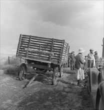 Migratory cotton pickers have stopped working because it started to rain, Kern County, CA, 1938. Creator: Dorothea Lange.