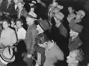 Street meeting at night in Mexican town outside of Shafter, California, 1938. Creator: Dorothea Lange.