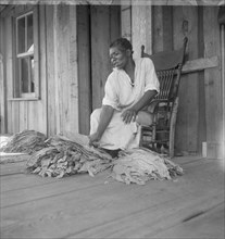 Near Douglas, Georgia. Sharecroppers grade the cured leaves, 1938. Creator: Dorothea Lange.
