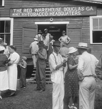 As the auctioneer knocks down the last bid on each basket of tobacco..., Douglas, Georgia, 1938. Creator: Dorothea Lange.