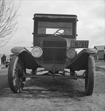 Model T Fords still carry migrants, FSA migratory labor camp at Farmersville, California , 1939. Creator: Dorothea Lange.