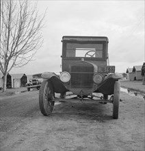 Model T Fords still carry migrants, FSA migratory labor camp at Farmersville, CA, 1939. Creator: Dorothea Lange.