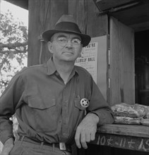 Deputy sheriff, stationed at paymaster's window..., near Grants Pass, Josephine County, Oregon, 1939 Creator: Dorothea Lange.