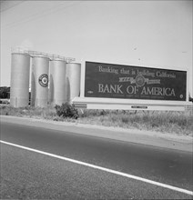 Highway gas tanks and signboard approaching town, between Tulare and Fresno on U.S. 99, 1939. Creator: Dorothea Lange.