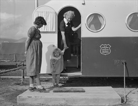 Young mother brings her child to the trailer clinic..., FSA, Merrill, Klamath County, Oregon, 1939. Creator: Dorothea Lange.
