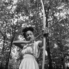Loretta Gyles pulling a bow at Camp Fern Rock, Bear Mountain, New York, 1943 Creator: Gordon Parks.