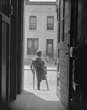 Young boy standing in the doorway of his home on Seaton Road...,Washington, D.C, 1942. Creator: Gordon Parks.