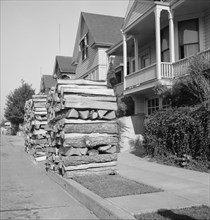 Woodpiles along the street are a characteristic of Portland, Oregon, 1939. Creator: Dorothea Lange.