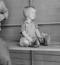 Baby with club feet wearing homemade splints, FSA camp, Tulare County, California, 1939. Creator: Dorothea Lange.
