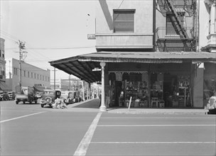 Street corner of San Joaquin Valley town on U.S. 99 showing secondhand store, Fresno, CA, 1939. Creator: Dorothea Lange.
