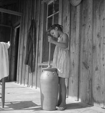 Pottery butter churn on porch of Negro tenant family, Randolph County, N Carolina, 1939. Creator: Dorothea Lange.