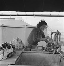 Young migrant girl makes use of facilities..., Merrill FSA camp, Klamath County, Oregon, 1939. Creator: Dorothea Lange.