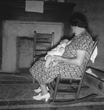 Tobacco sharecropper's wife nurses the baby after washing..., Person County, North Carolina, 1939. Creator: Dorothea Lange.