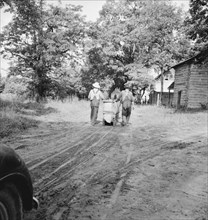 Mr. Taylor and wage laborer slide tobacco..., Granville County, North Carolina, 1939. Creator: Dorothea Lange.