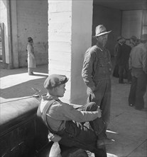 Pea pickers waiting at FSA office for issue of surplus commodities, Calipatria, California, 1939. Creator: Dorothea Lange.