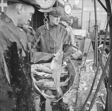 Possibly: New England fishermen unloading fish at the Fulton fish market, New York, 1943. Creator: Gordon Parks.