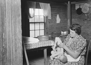 Wife of tobacco sharecropper bathing her baby..., Person County, North Carolina, 1939. Creator: Dorothea Lange.