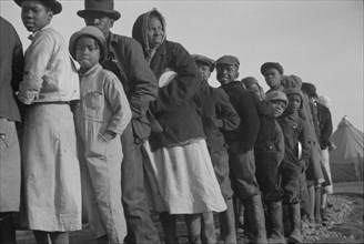 Possibly: Negroes in the lineup for food at the flood refugee camp, Forrest City, Arkansas, 1937. Creator: Walker Evans.