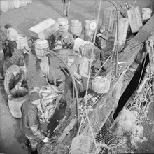 Stevedores at the Fulton fish market unloading fish from boats caught..., New York, 1943. Creator: Gordon Parks.
