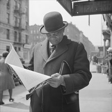 A Marcus Garveyite reading the OWI publication Negroes and the War, New York, 1943. Creator: Gordon Parks.