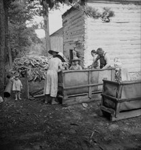 Wives of tobacco tenants pile the tobacco..., Granville County, North Carolina, 1939. Creator: Dorothea Lange.