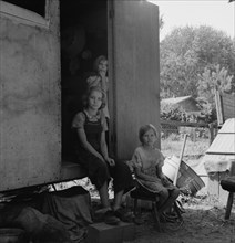The oldest girl seated in the doorway of the house trailer..., Yakima Valley, Washington, 1939. Creator: Dorothea Lange.
