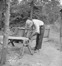 Zollie Lyons repairing the tobacco sleds at...harvest season, Wake County, North Carolina, 1939. Creator: Dorothea Lange.