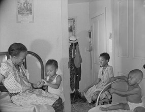 Adopted daughter and two grandchildren with Mrs. Ella Watson...charwoman, Washington, D.C, 1942. Creator: Gordon Parks.