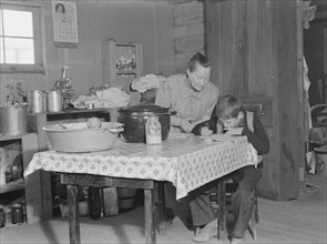 The youngest Wardlow boy copies out a recipe for his mother. Dead Ox Flat, Malheur County, Oregon.