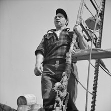 New York, New York. Gloucester fisherman standing in the rigging of a New England fishing boat.