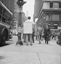 42nd Street and Madison Avenue. Street hawker selling Consumer's Bureau Guide. New York City.