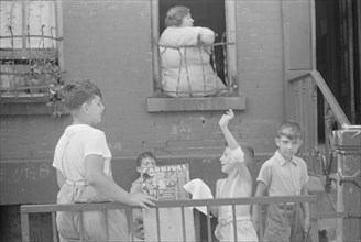 New York, New York. 61st Street between 1st and 3rd Avenues. Children playing in the street.