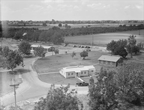 Entrance to camp showing clinic (light building in foreground). Farmersville, California.