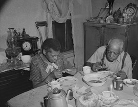 Washington, D.C. Elderly couple eating dinner at their home on Lamont Street, N.W..