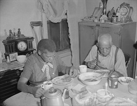 Washington, D.C. Elderly couple eating dinner at their home on Lamont Street, N.W..