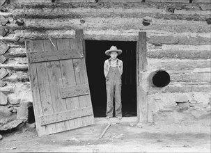 North Carolina farm boy in doorway of tobacco barn. Person County, North Carolina.