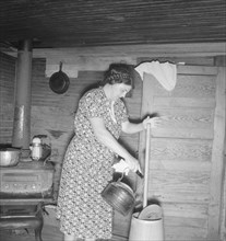 Wife of tobacco sharecropper cleaning butter churn. Person County, North Carolina.